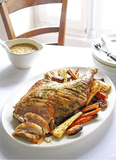 Roast shoulder of lamb and root vegetables with an onion sauce