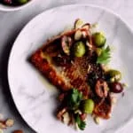 Pescado con piel crujiente, aceitunas y almendras