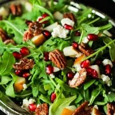 Ensalada de rúcula con granada, queso de cabra y nueces caramelizadas