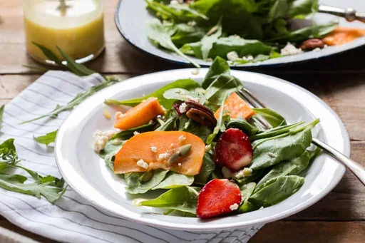 Ensalada de brotes y caqui con requesón y aderezo de naranja