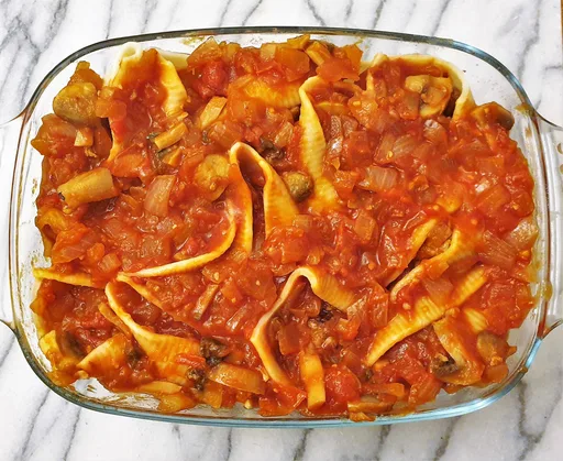 Caracolas de pasta gigantes rellenas de albóndigas con salsa de tomate
