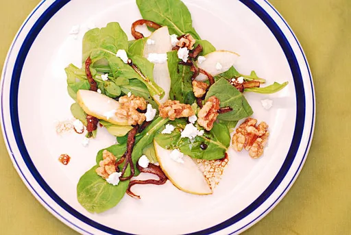 Ensalada de rúcula con cebolla caramelizada, nueces, peras y queso Gorgonzola