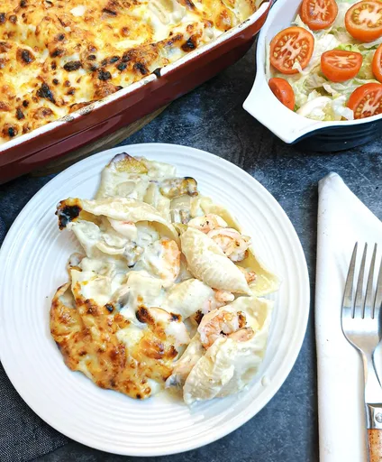 Conchas de pasta rellenas de marisco en salsa cremosa de queso