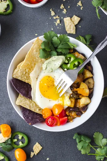 Bol de tacos para el desayuno con salsa de aguacate y cilantro