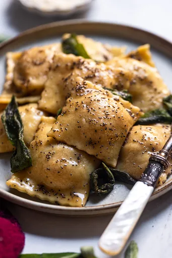 Raviolis de calabaza asada con salsa de mantequilla tostada y amapola