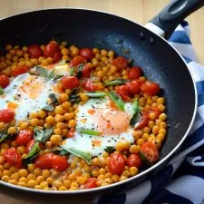 Huevos al horno con garbanzos, tomates y albahaca