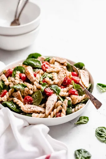 Ensalada de pasta con pollo, espinacas y tomates