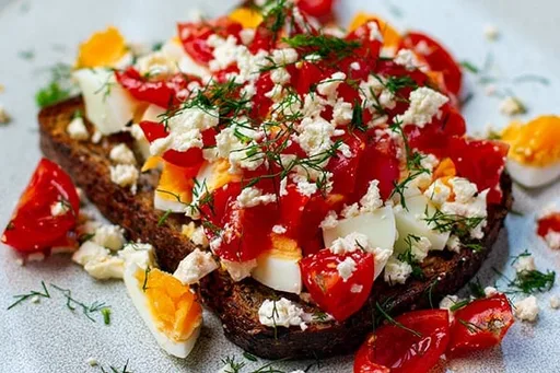 Huevos sobre tostada con feta y tomates