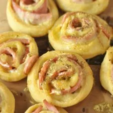 Rollitos calientes de jamón y queso con glaseado de mantequilla a la Dijon