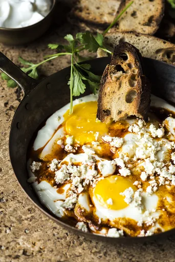 Huevos fritos en yogur con ajo y queso feta