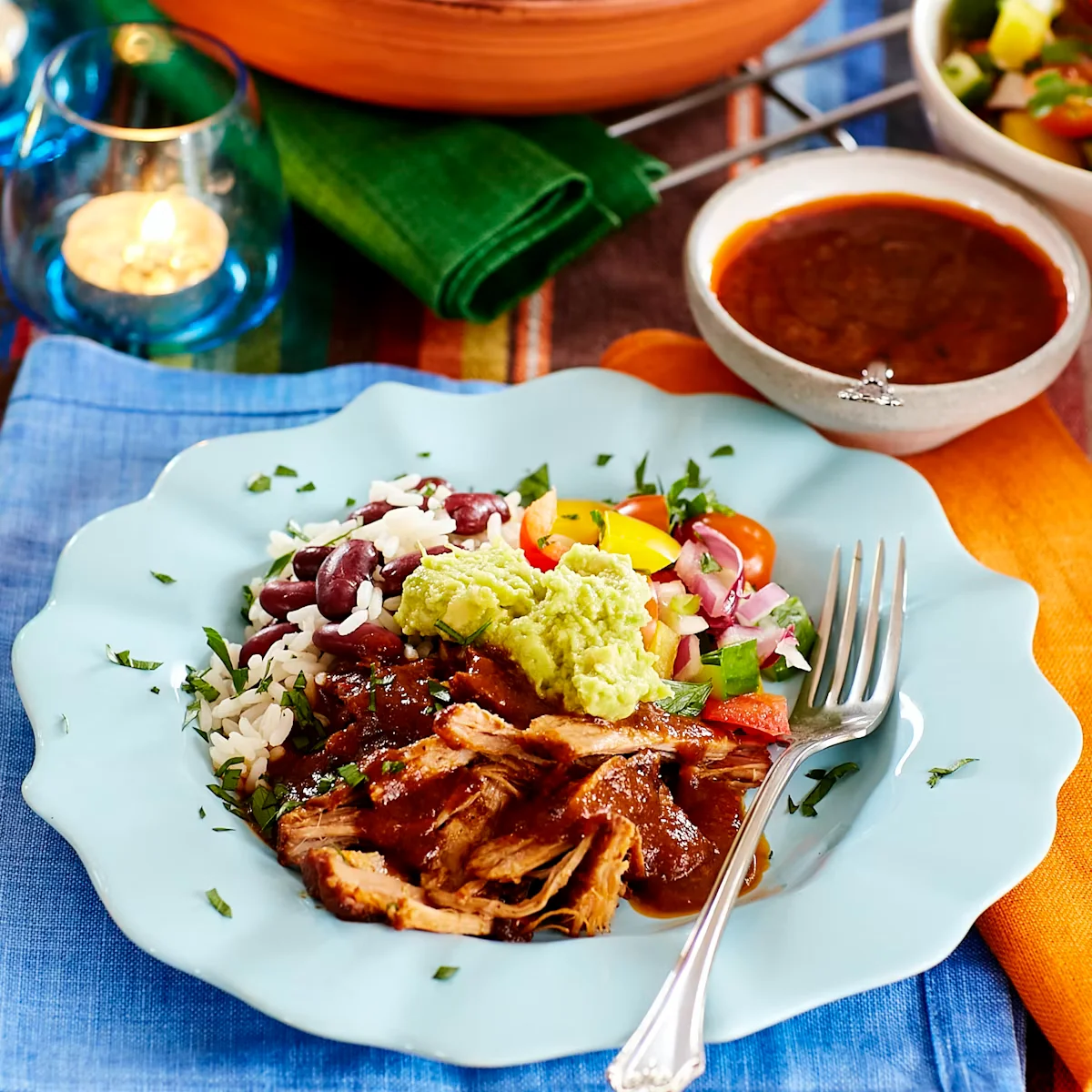 Slow-cooked pulled pork in a clay pot with taco seasoning