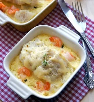 Poisson au four sur un lit de poireaux et de crevettes, au lait de coco et au fromage