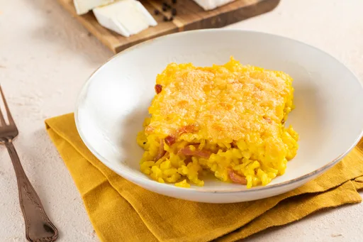 Oven-baked rice with saffron, speck and brie