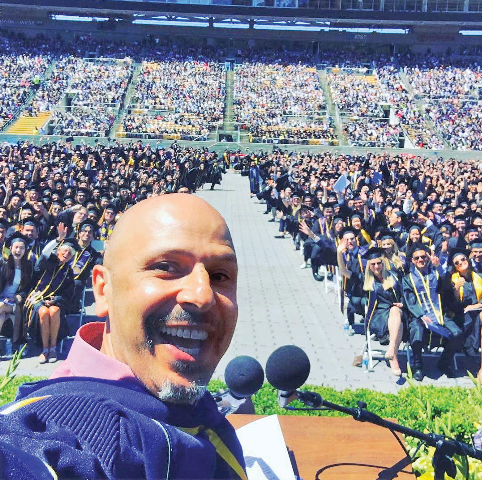 Photo of Maz Jobrani takes a selfie with graduating senior class