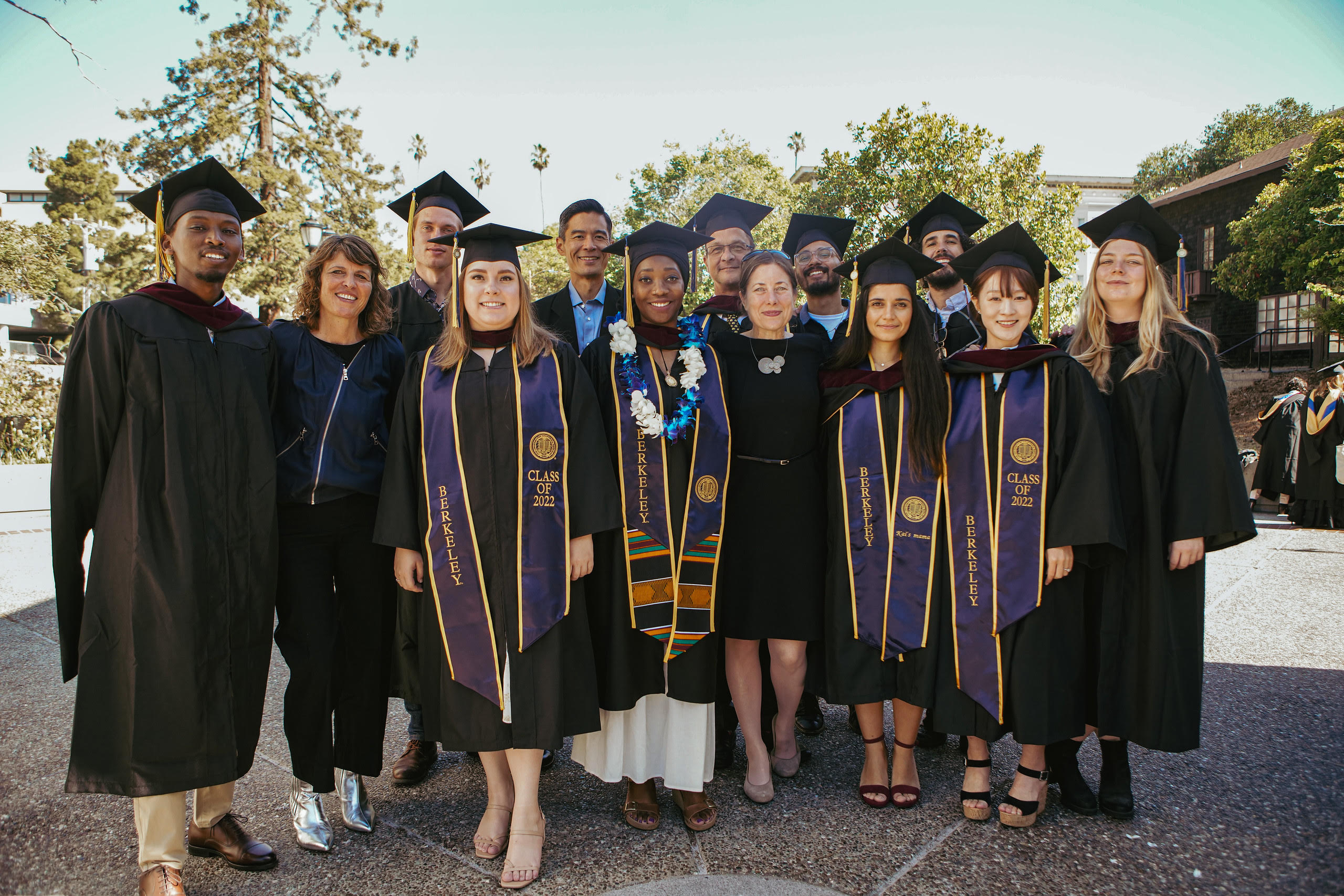 Color photo of Redfearn and students, the students in Cal commencement regalia.