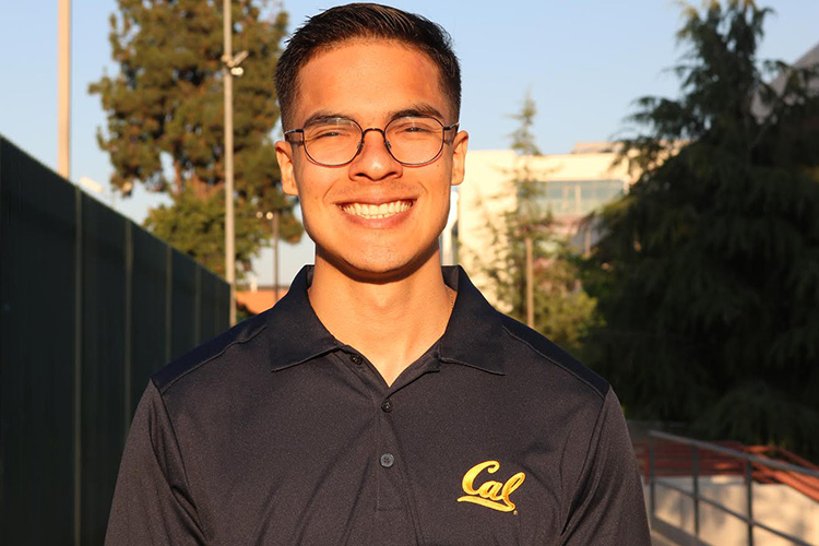 Photo of Daniel in a black shirt with the Cal script, glasses, and dark brown hair.