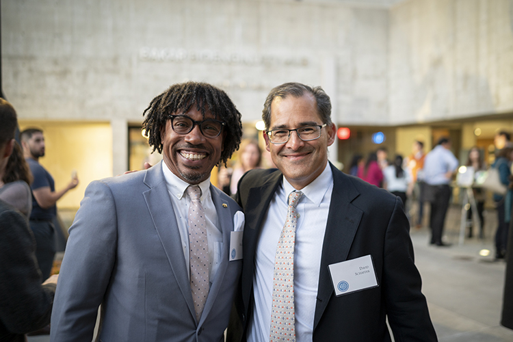 Color photo of the two men smiling at the camera.