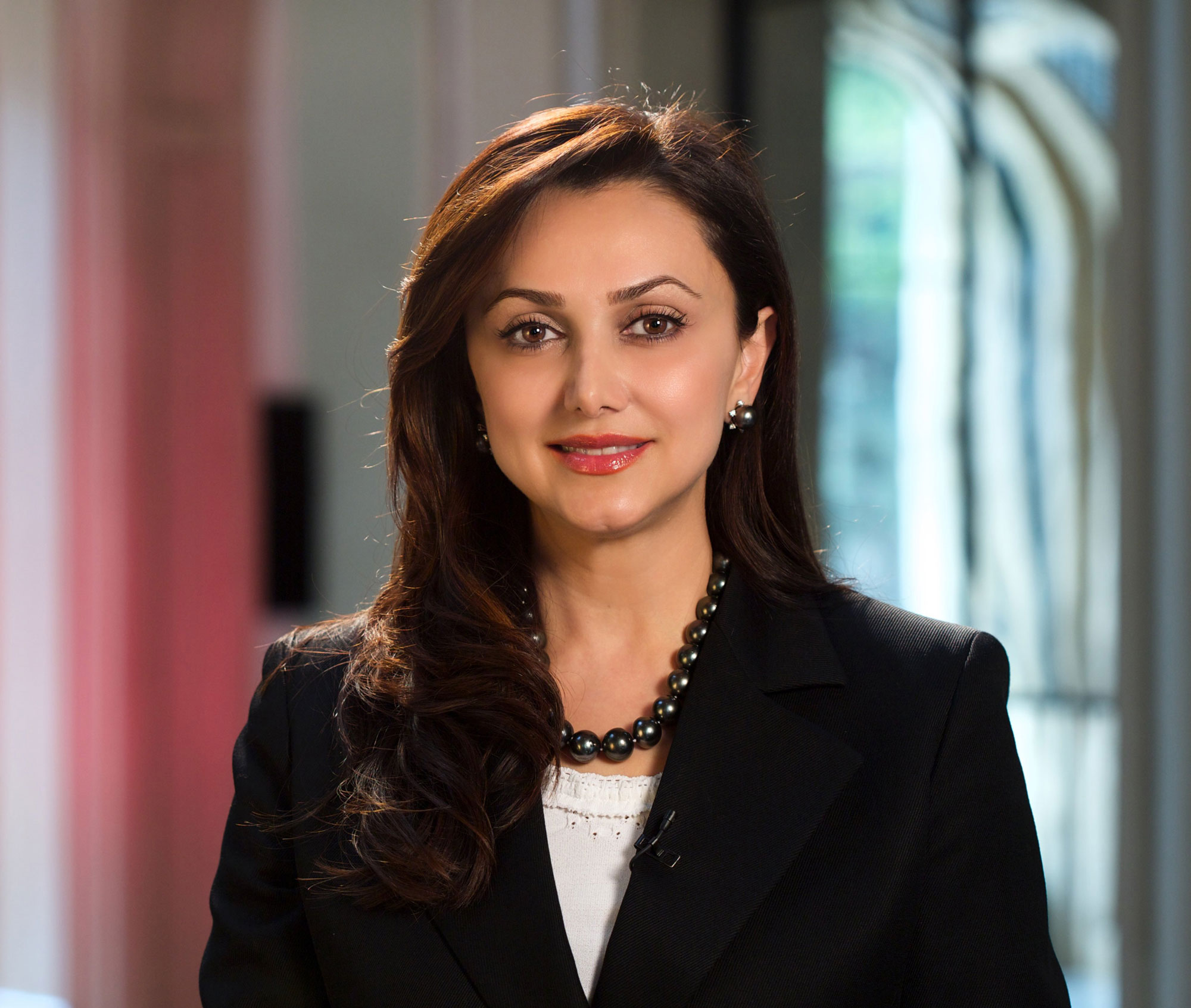 Photo of Bita smiling in a black jacket and beaded necklace