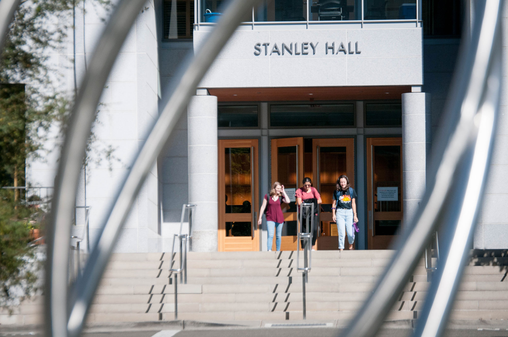 Photo of three students exiting the steps of Stanley Hall.