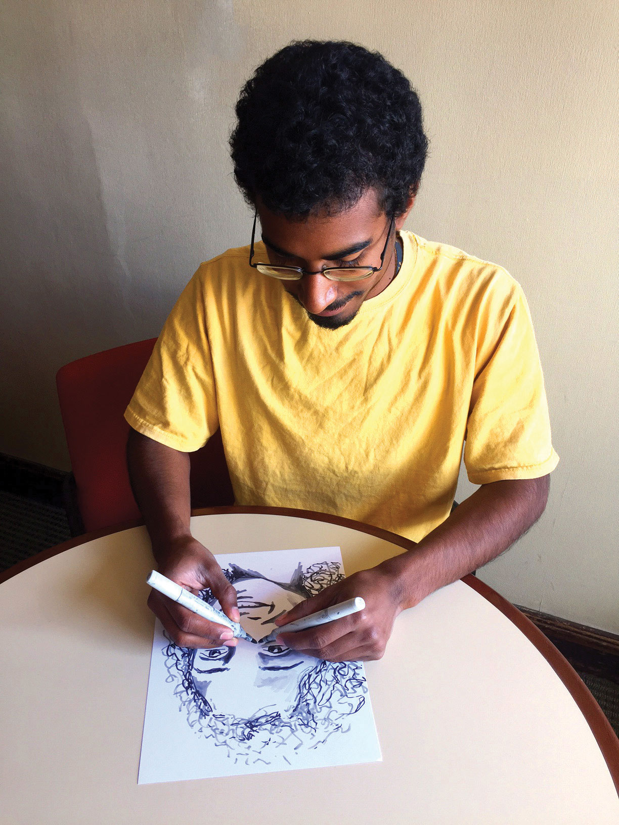 Photo of Randall drawing the portrait of a fellow I-House resident.