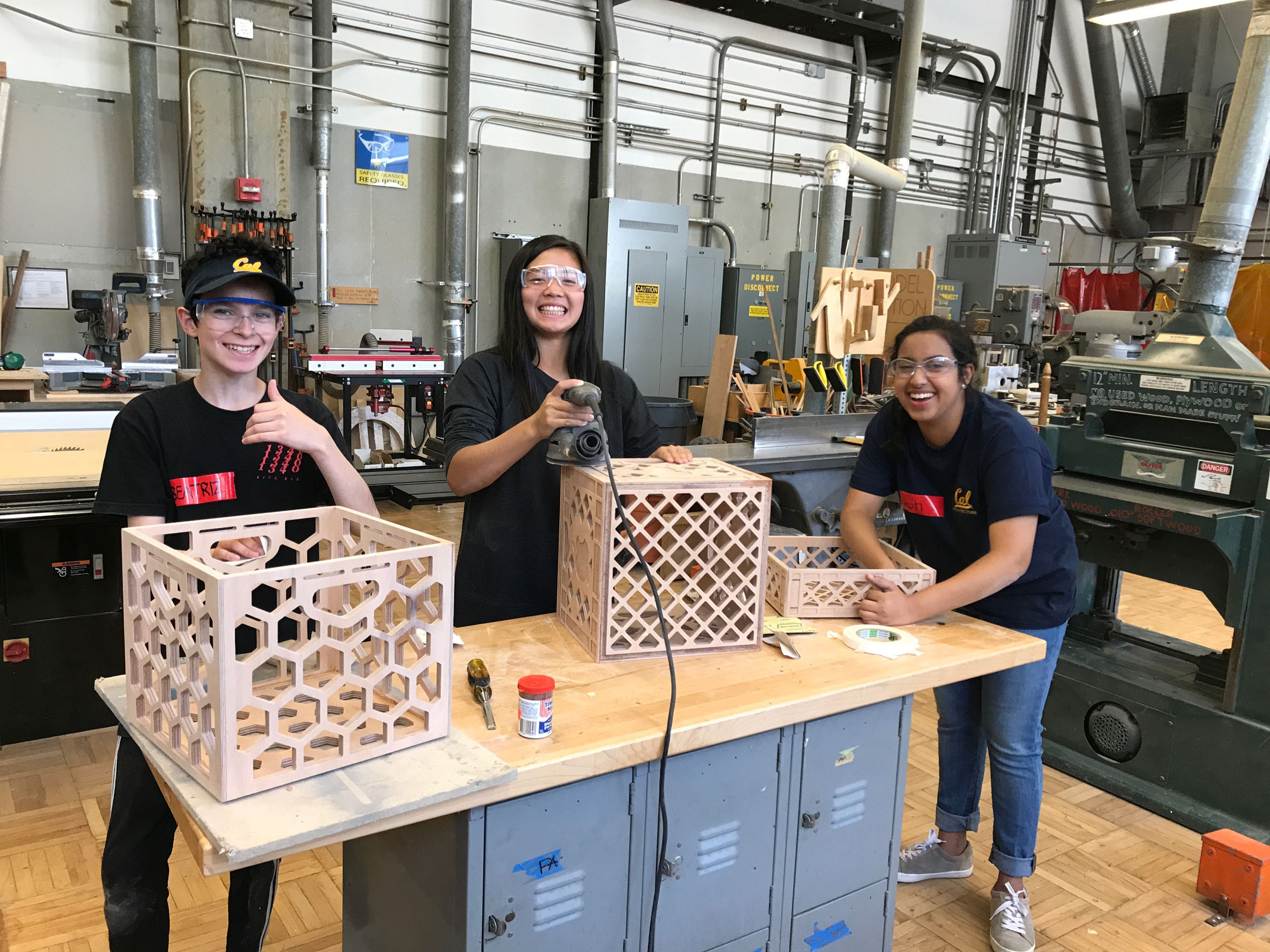 Photo of CED students with wooden structures they are building in a lab