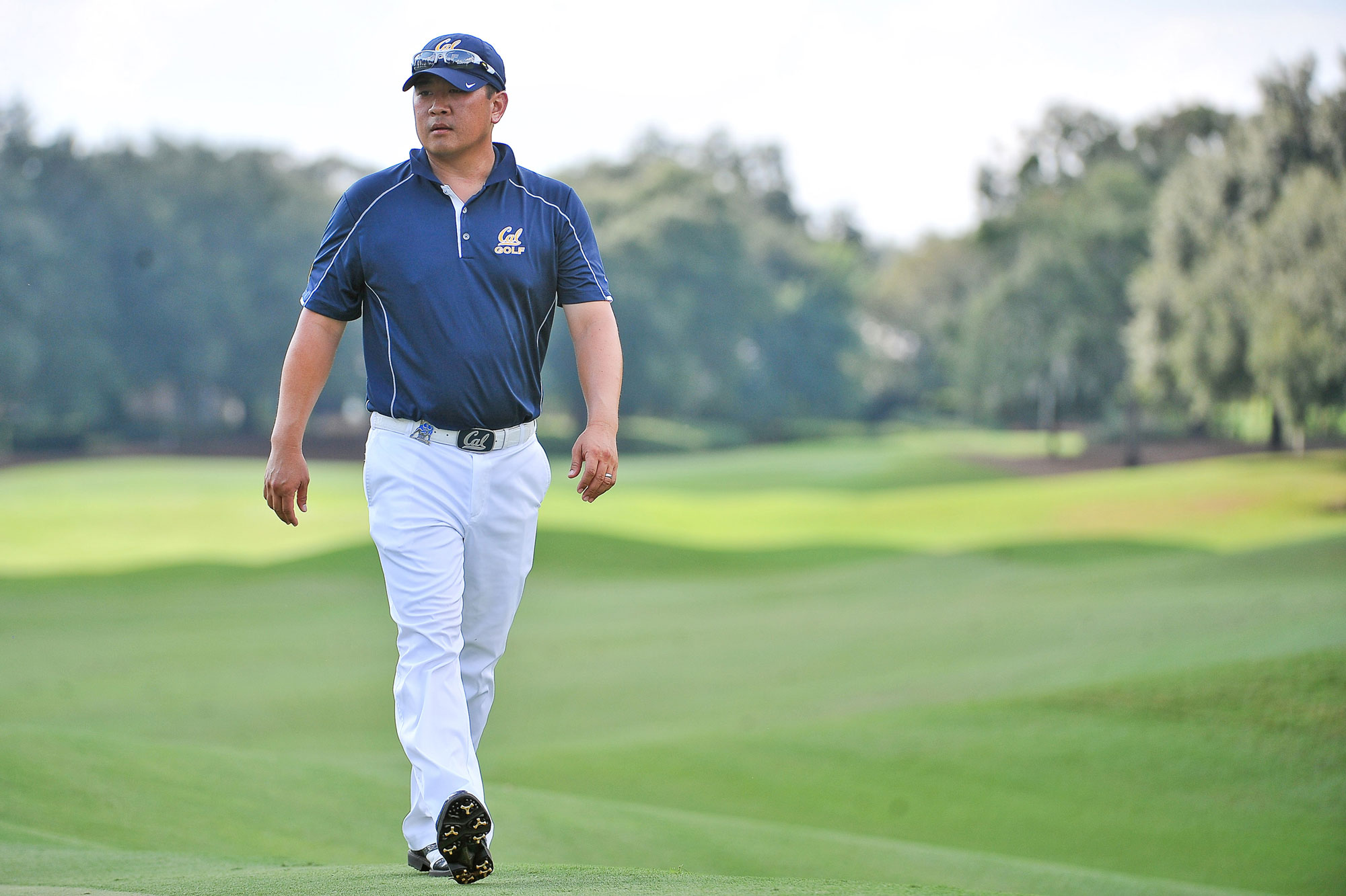 Photo of Chun in a Cal shirt walking on a golf course.