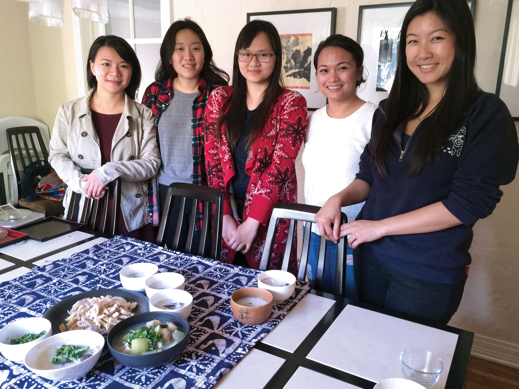 Ladies standing in front of table served with food.