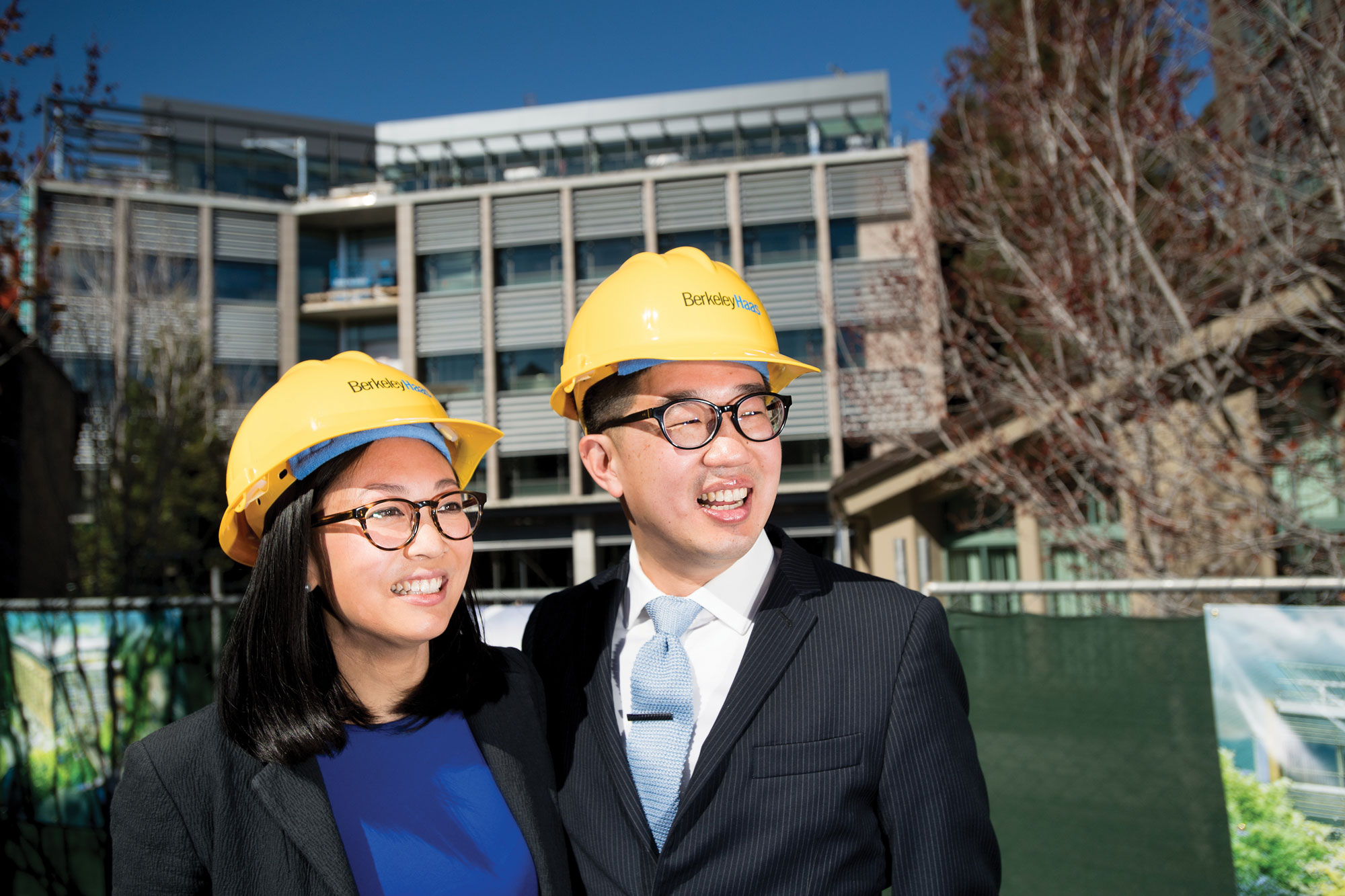 Photo of man and woman smiling and posing, wearing hard hats.