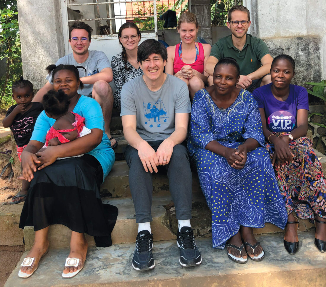 Photo of 10 people, including two children, seated on steps and smiling.