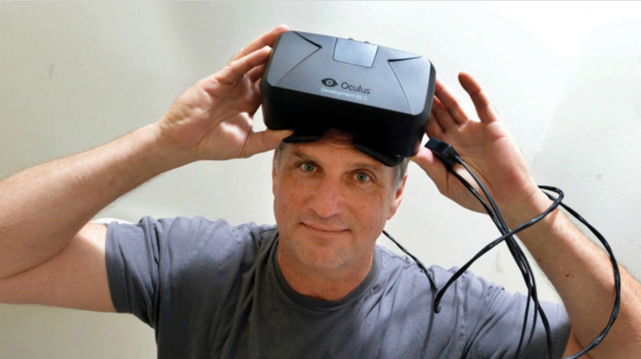 Photo of Jack McCauley wearing an Oculus Rift VR headset on top of his head