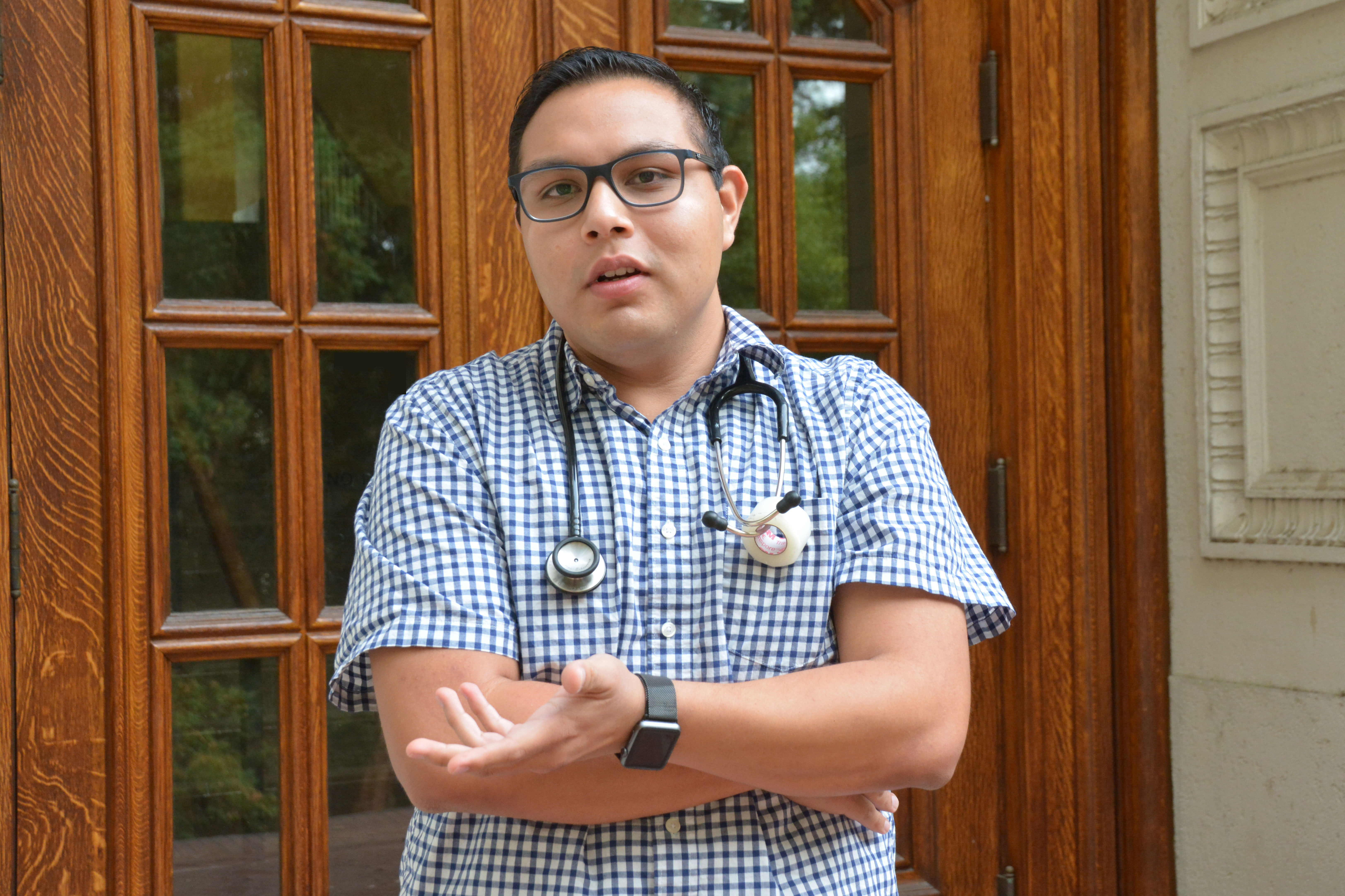 Photo of Juan Medina-Echeverria ’17 wearing a stethoscope and gesturing