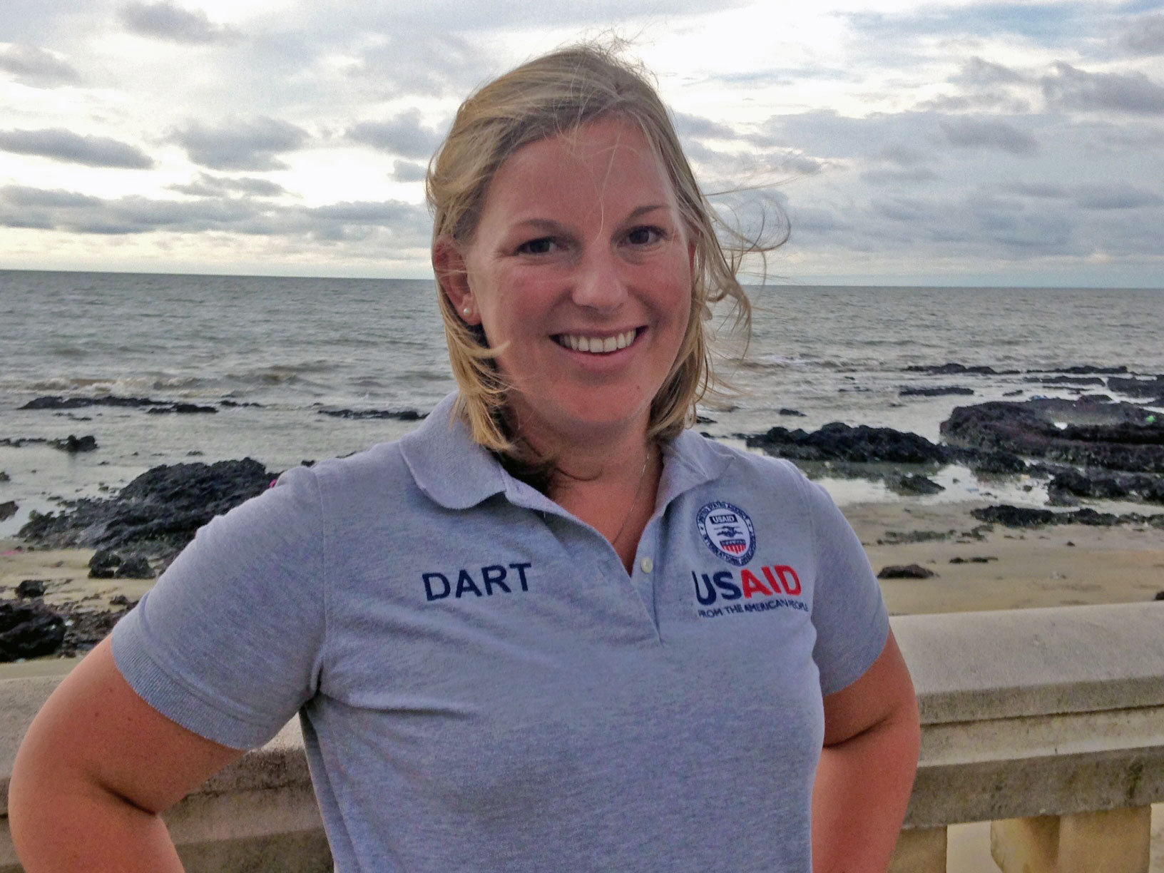 Photo of Sofie in a USAID shirt on a beach.