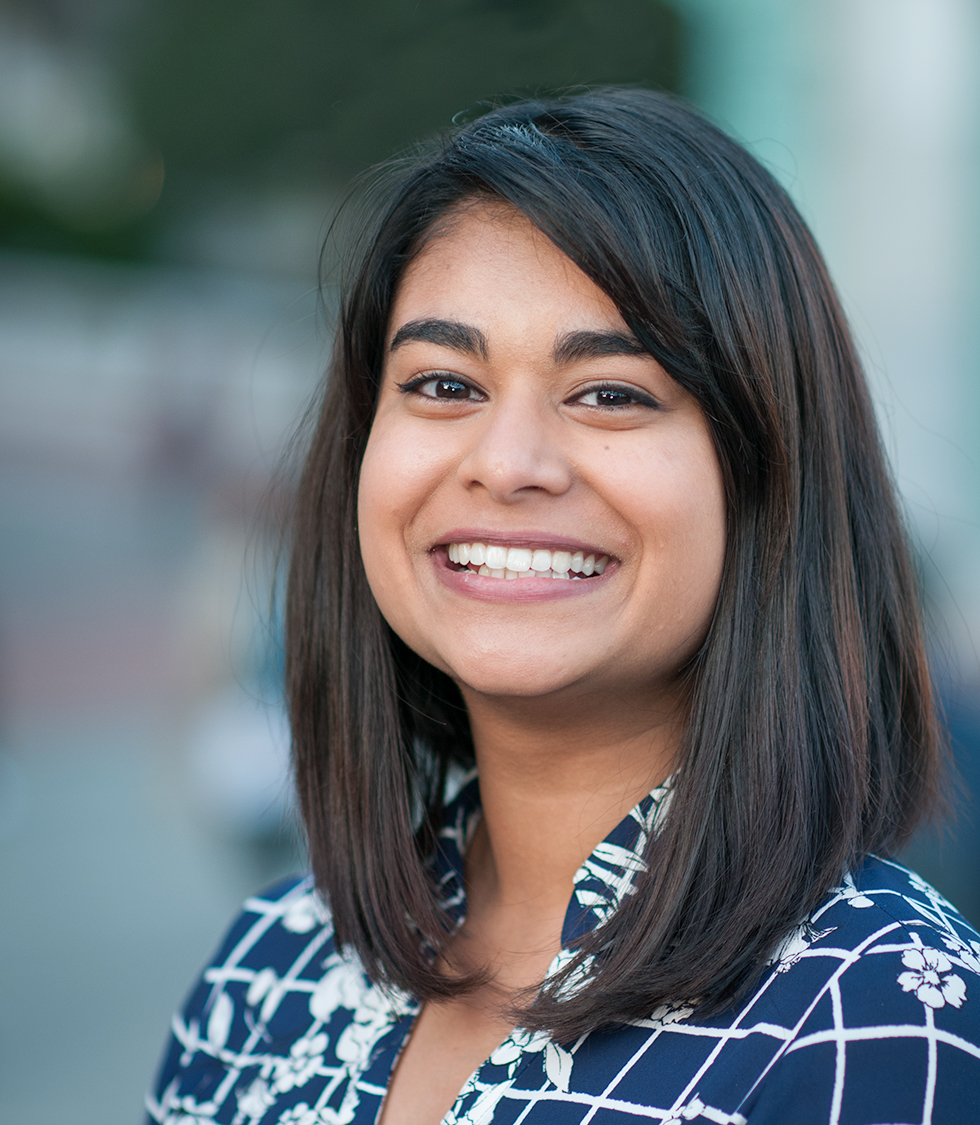 Photo of Tanisha smiling in a blue floral top.