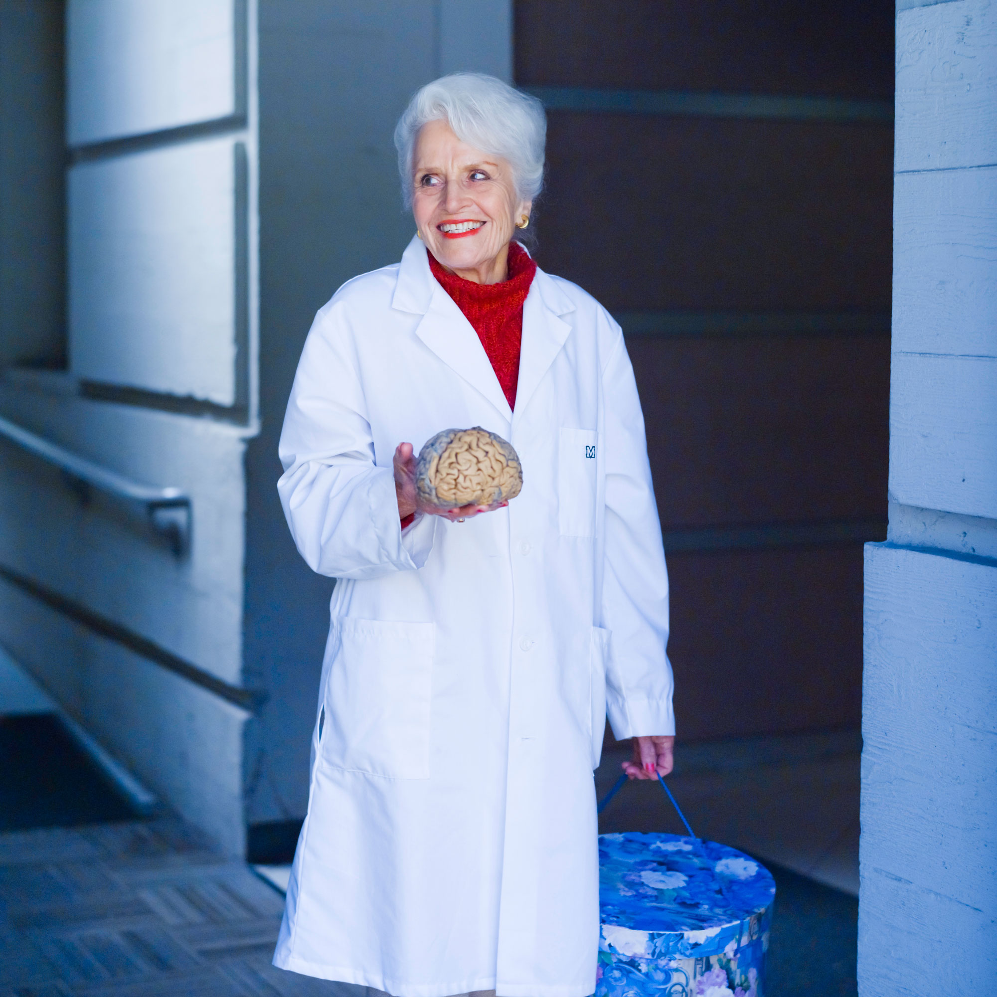 Photo of Professor Diamond in a lab coat holding a model of a brain.