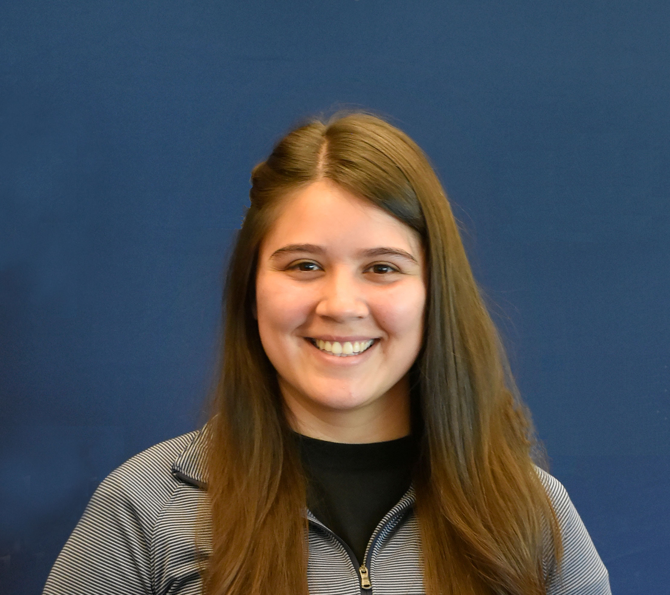 Photo of Cendejas ’17 smiling against a blue background.