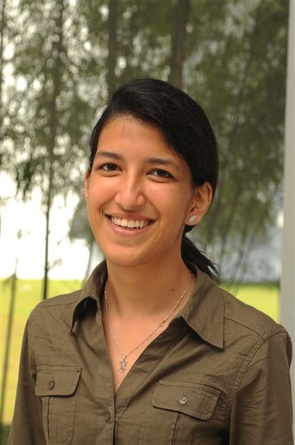 Photo of Yutika smiling in front of trees.