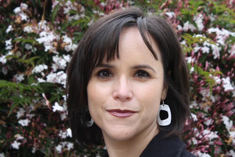 Headshot photo of Lisa García Bedolla, vice provost for graduate studies and dean of the graduate division, with jasmine flowers blooming int he background.