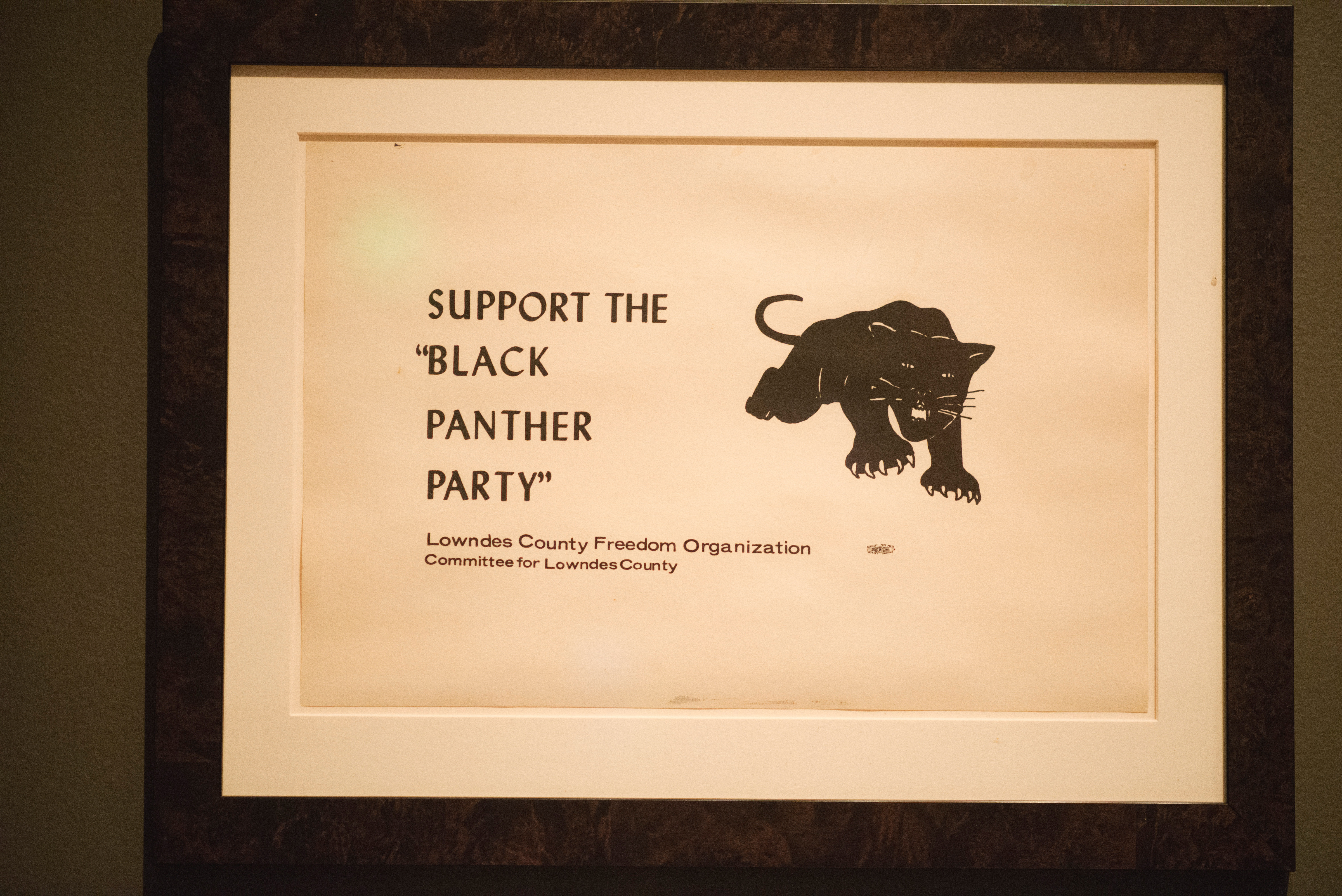 Photo of a framed poster featuring the Black Panther logo and the words 