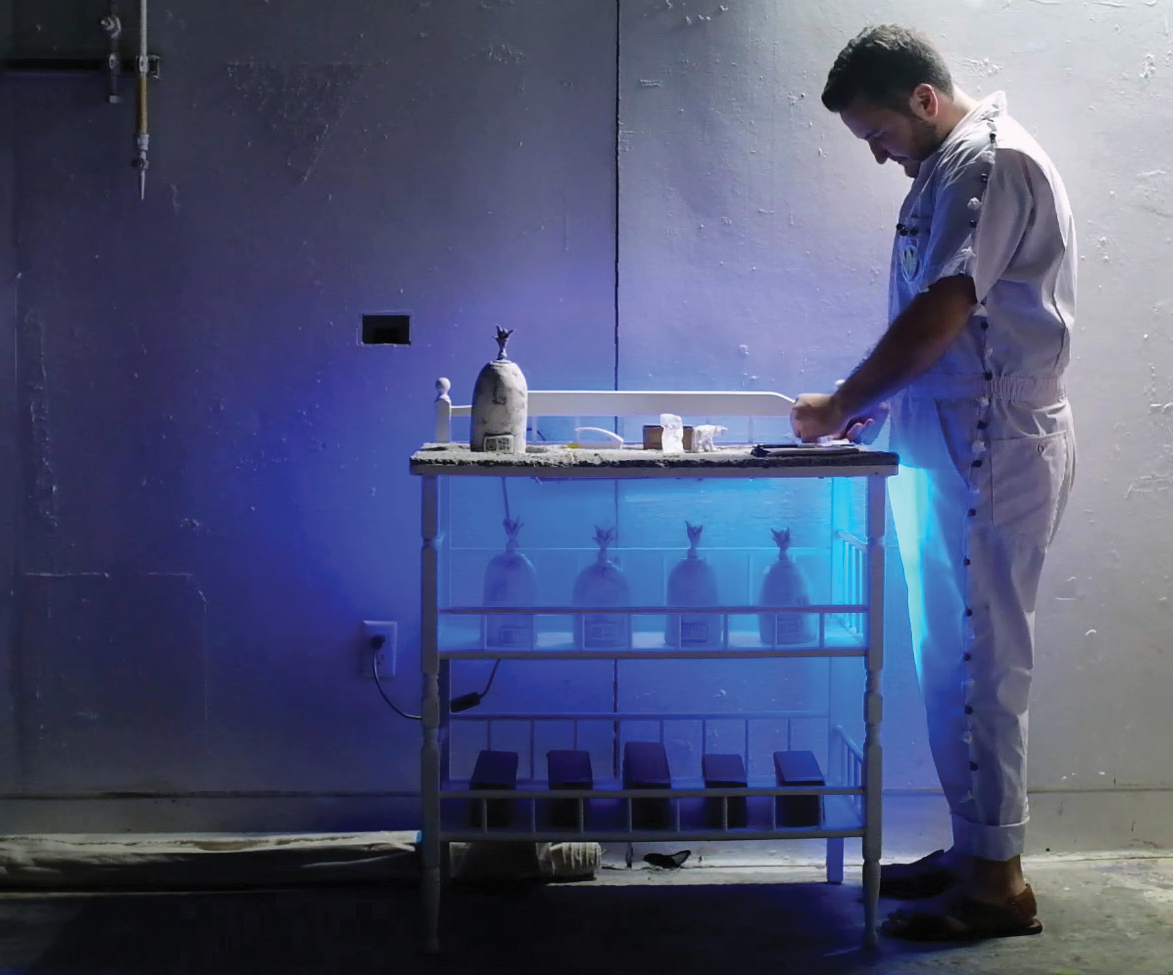 A photo of Alvaro Azcarraga ’18 interacting with his installation of a fictional lab.