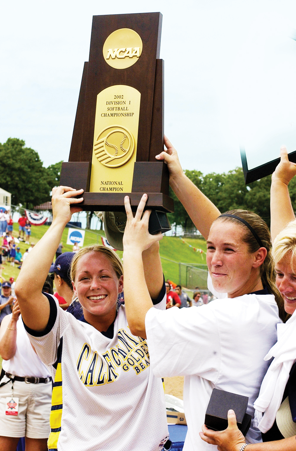 Photo of several teammates joyfully holding up a trophy.