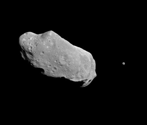 Black and white photo of an oblong, puckered asteroid.