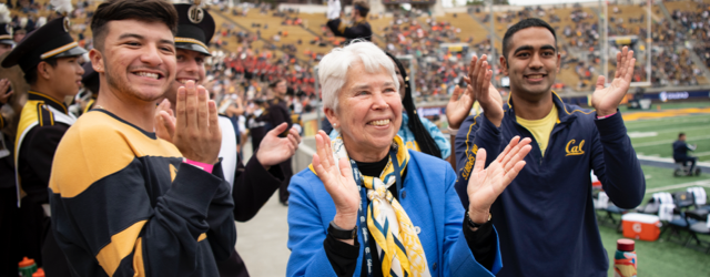 Photo of Chancellor Christ applauding with students at a sports game