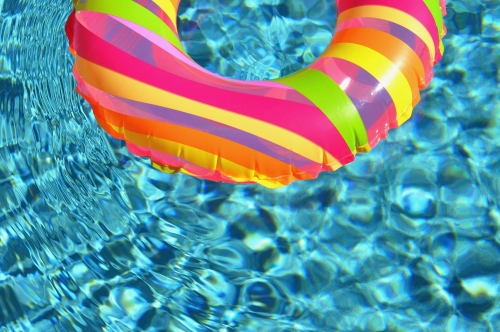 rainbow pool ring float in clear pool water