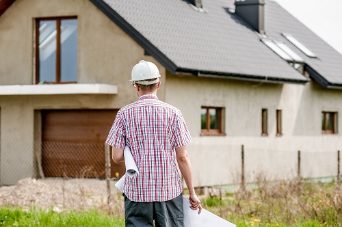 Photo of an architect in front of a house