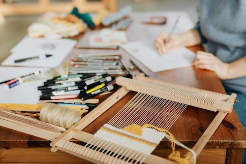 person sitting at table with art supplies