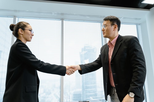 Two businesspeople shaking hands in suits