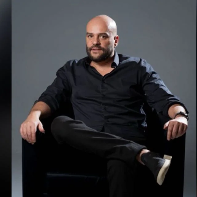 Rodrigo Caggiano sentado em uma poltrona