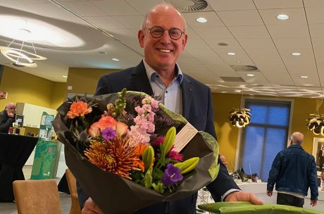 Foto van Henk Hartemink met een bos bloemen