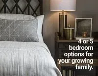 The text says 4 or 5 bedroom options for your growing family. The picture shows a comfortable-looking bed with a nightstand that has a lamp, candle and picture frame. This is for the Aspire, a two-storey home in Cornerbrook by Cardel Homes.