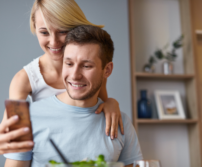 Wesołe małżeństwo patrzące w telefon 